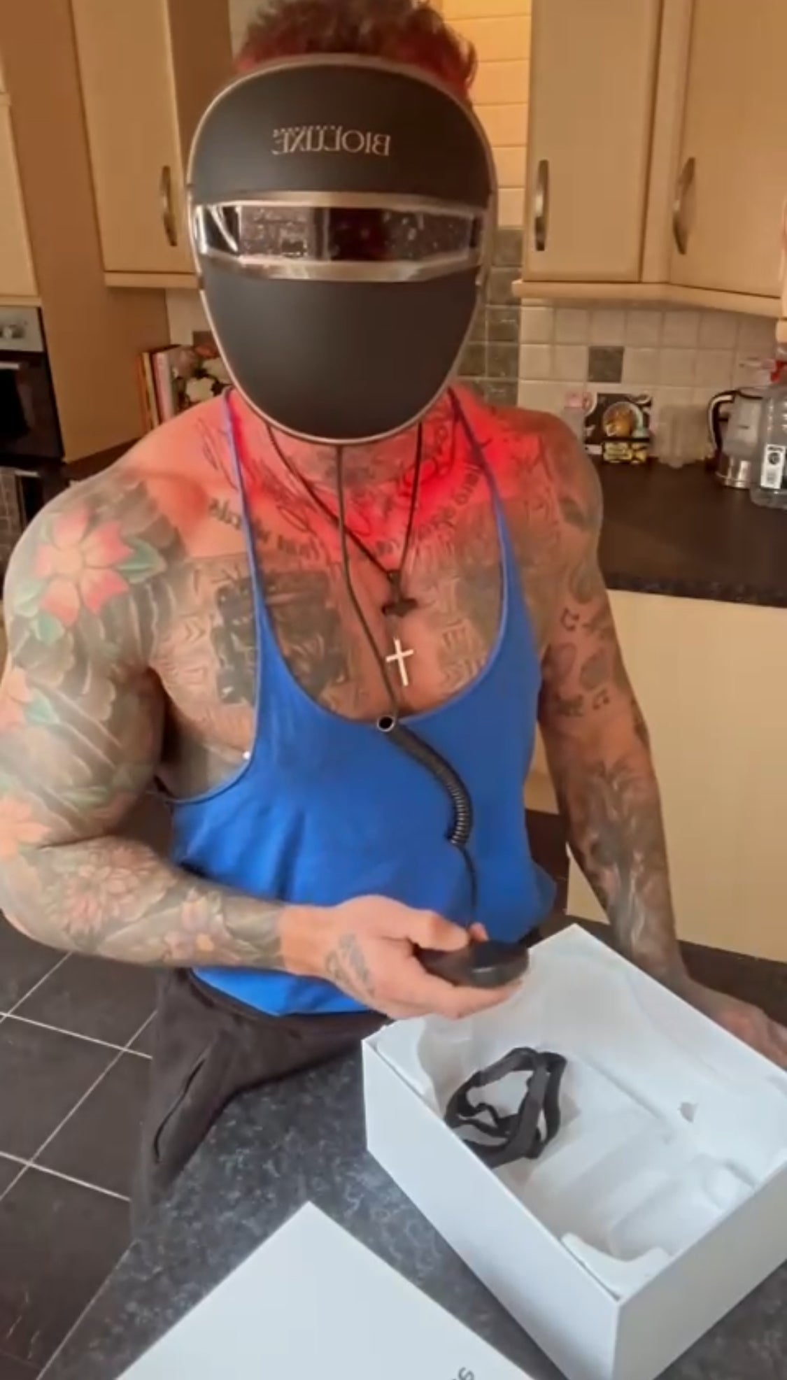 Person using red light therapy panel at home for wellness LED red light therapy device glowing in a dark room Woman relaxing under red light therapy for skin rejuvenation